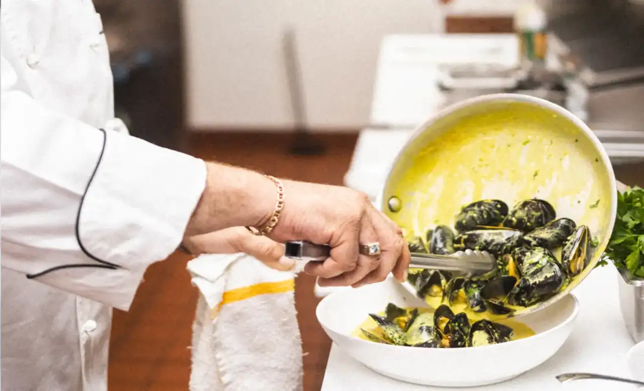 chef preparing mussels in a skillet